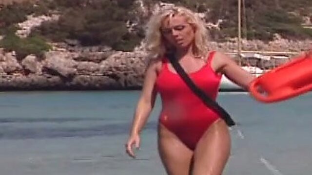 Saucy blond haired MILF in red swim suit performs steamy solo on sandy beach