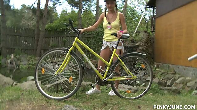 Young blonde is riding her bicycle and masturbating pussy outdoor