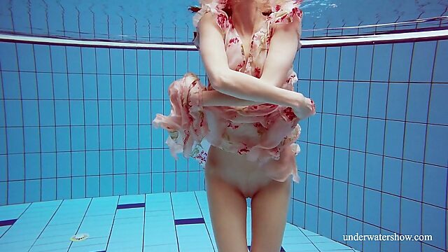 Red haired hottie Martina is stripping under the water